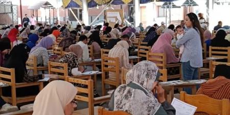 أستاذة جامعية ببورسعيد تحمل رضيعة طالبة أثناء الامتحان لتساعدها على التركيز.. صور